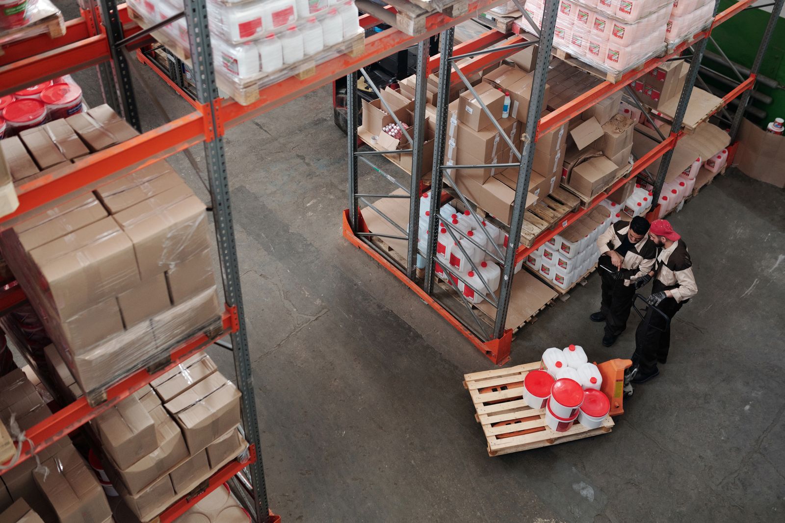 Warehouse colleagues reviewing inventory among storage racks